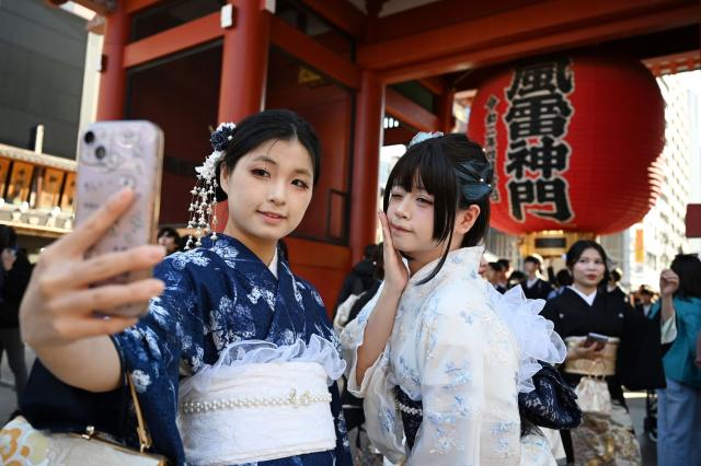 Two Chinese tourists wear kimonos as they visit the Sensoji Temple in the Asakusa district of Tokyo on November 15, 2025. China has advised its citizens to avoid travelling to Japan, following a diplomatic feud sparked by remarks from Tokyo's new premier about a hypothetical attack on Taiwan. (Photo by GREG BAKER / AFP)