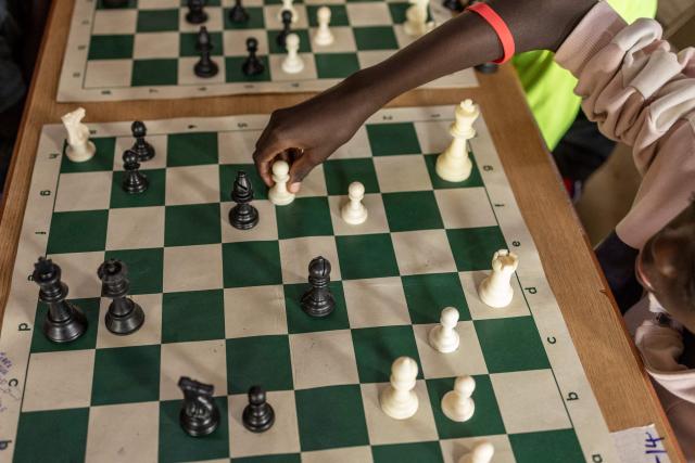 A young chess player makes a move during the Kibera Chess Tournament in Kibera, Nairobi, on November 15, 2025. The tournament brought together 195 children from different informal settlements, with the aim to nurture young minds, strengthen critical thinking, and inspire the next generation. (Photo by SIMON MAINA / AFP)