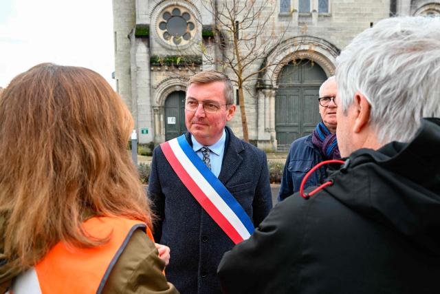 Mayor of Verdun Samuel Hazard (C) stands during a protest in front of the Saint-Jean-Baptiste church, where took place a religious ceremony "in homage to Marshal Pétain and his soldiers" organised by ADMP (Association to Defend the Memory of Marshal Petain) in Verdun, northeastern France on November 15, 2025. The administrative court authorized the religious ceremony the day before, ruling against the city's mayor who had banned it by decree. (Photo by Jean-Christophe VERHAEGEN / AFP)