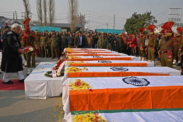 Lieutenant Governor of Jammu and Kashmir Manoj Sinha (L) lays a wreath on the coffins of the deceased victims in an accidental blast at Nowgam police station, on the outskirts of Srinagar, on November 15, 2025. (Photo by Tauseef MUSTAFA / AFP)
