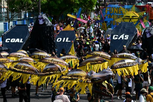 Activists perform the death of fossil fuels at the so-called "Great People's March" in the sidelines of the COP30 UN Climate Change Conference in Belem, Para State, Brazil on November 15, 2025. Thousands of people are expected to attend the march to demand "real solutions" to human-caused global warming , and which comes at the halfway point of contentious COP30 negotiations following two Indigenous-led protests that disrupted proceedings earlier in the week. (Photo by Pablo PORCIUNCULA / AFP)