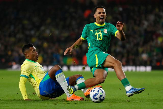 Brazil's defender #06 Alex Sandro (L) tackles Senegal's forward #13 Iliman Ndiaye during the International friendly football match between Brazil and Senegal at The Emirates Stadium in London on November 15, 2025. (Photo by Ian Kington / AFP)