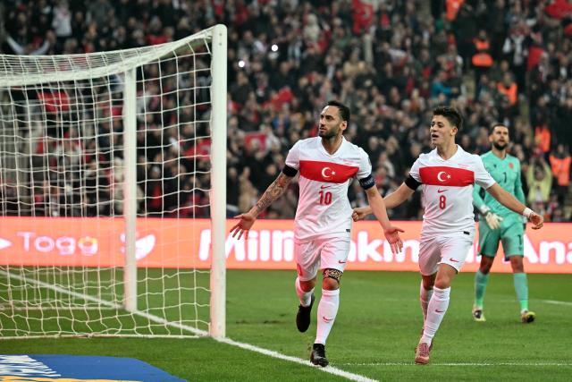 Turkey's midfielder #10 Hakan Calhanoglu (C) celebrates with Turkey's midfielder #08 Arda Guler after scoring a penalty during the FIFA World Cup 2026 European qualification football match between Turkey and Bulgaria at the Timsah Arena stadium, in Bursa, on November 15, 2025. (Photo by OZAN KOSE / AFP)