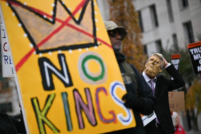 A man wearing a mask of US President Donald Trump with a Pinocchio nose and carrying a box reading "Classified Epstein Files" takes part in the "Surround the White House 1.0" protest against US President Donald Trump in front of the White House in Washington, DC, on November 15, 2025. (Photo by Drew ANGERER / AFP)