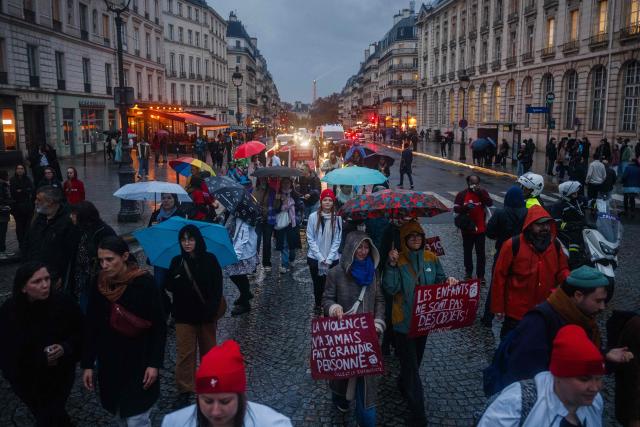 Protesters march through central Paris during a demonstration to denounce violence against children and teenagers ahead of International Children's Rights Day, in Paris on November 15, 2025. (Photo by Dimitar DILKOFF / AFP)