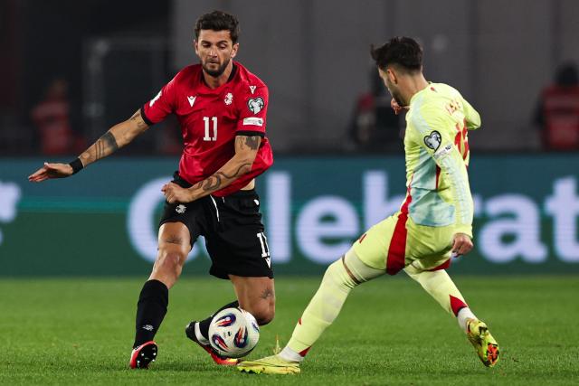 Georgia's forward Giorgi Kvilitaia and Spain's midfielder #16 Alex Baena vie for the ball during the FIFA World Cup 2026 European qualification football match between Georgia and Spain at the Boris Paichadze National Stadium in Tbilisi on November 15, 2025. (Photo by Giorgi ARJEVANIDZE / AFP)