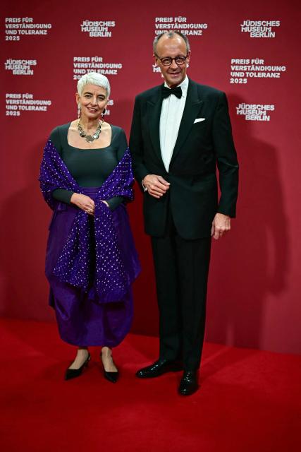 German Chancellor Friedrich Merz (R) and Hetty Berg, director of the Jewish Museum Berlin (JMB), pose for a photo as they arrive the awarding of the "the Prize for Understanding and Tolerance" by the Jewish Museum Berlin (JMB) in Berlin on November 15, 2025. This year, the prize goes to Amy Gutmann, former US Ambassador to Germany, Christopher H. Browne, Professor at the University of Pennsylvania and Daniel Zajfman, former President of the Weizmann Institute of Science and Chairman of the Academic Advisory Board of the Israel Science Foundation. (Photo by Tobias SCHWARZ / AFP)