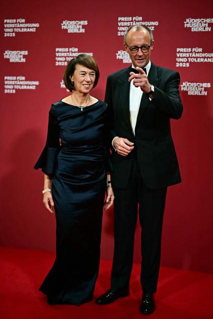 German Chancellor Friedrich Merz (R) and his wife Charlotte Merz, pose for a photo as they arrive the awarding of the "the Prize for Understanding and Tolerance" by the Jewish Museum Berlin (JMB) in Berlin on November 15, 2025. This year, the prize goes to Amy Gutmann, former US Ambassador to Germany, Christopher H. Browne, Professor at the University of Pennsylvania and Daniel Zajfman, former President of the Weizmann Institute of Science and Chairman of the Academic Advisory Board of the Israel Science Foundation. (Photo by Tobias SCHWARZ / AFP)