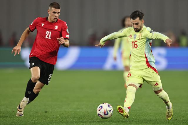 Georgia's forward #21 Giorgi Kvernadze and Spain's midfielder #16 Alex Baena vie for the ball during the FIFA World Cup 2026 European qualification football match between Georgia and Spain at the Boris Paichadze National Stadium in Tbilisi on November 15, 2025. (Photo by Giorgi ARJEVANIDZE / AFP)