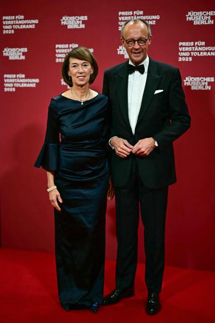 German Chancellor Friedrich Merz (R) and his wife Charlotte Merz, pose for a photo as they arrive the awarding of the "the Prize for Understanding and Tolerance" by the Jewish Museum Berlin (JMB) in Berlin on November 15, 2025. This year, the prize goes to Amy Gutmann, former US Ambassador to Germany, Christopher H. Browne, Professor at the University of Pennsylvania and Daniel Zajfman, former President of the Weizmann Institute of Science and Chairman of the Academic Advisory Board of the Israel Science Foundation. (Photo by Tobias SCHWARZ / AFP)