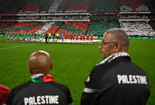 Both teams' players line up on the pitch to listen to their national anthems before the friendly football match between Basque Country and Palestine at San Mames Stadium in Bilbao on November 15, 2025. (Photo by ANDER GILLENEA / AFP)