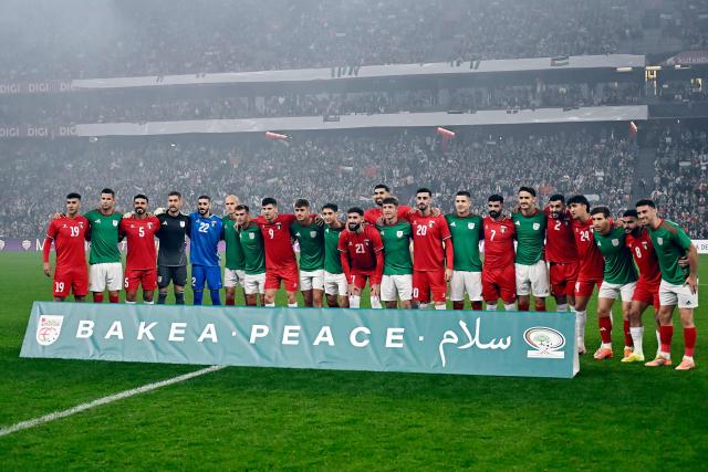 Both teams' players pose together behind a sign reading "Peace" in Basque, English and Arabic before the friendly football match between Basque Country and Palestine at San Mames Stadium in Bilbao on November 15, 2025. (Photo by ANDER GILLENEA / AFP)