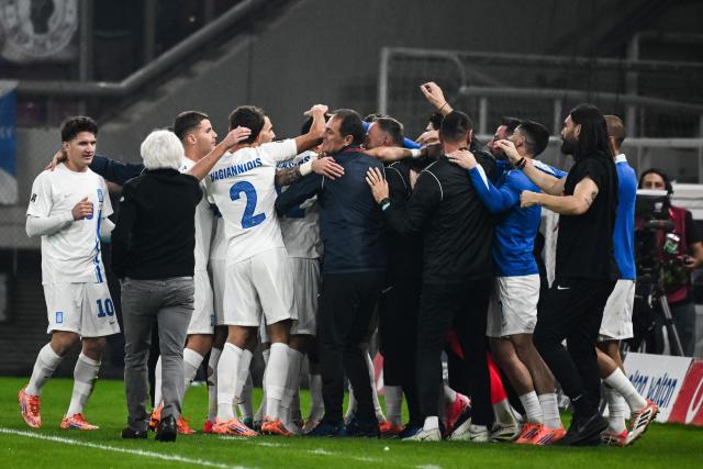 Greece's midfielder #11 Tasos Bakasetas celebrates with teammates and coaching staff after scoring Greece's first goal during the FIFA World Cup 2026 Group C European qualification football match between Greece and Scotland at the Karaiskakis Stadium in Piraeus, on November 15, 2025. (Photo by Angelos TZORTZINIS / AFP)