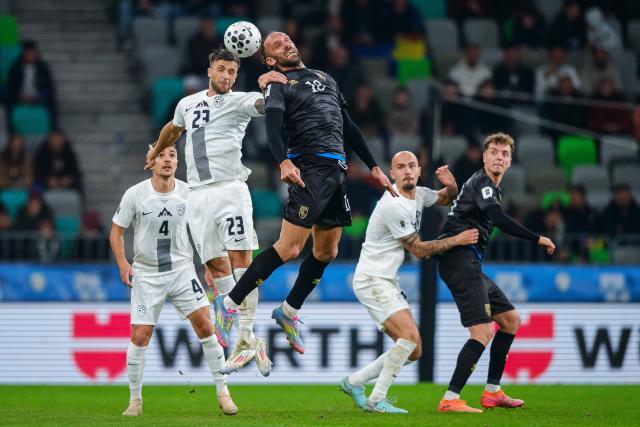 Slovenia's defender #23 David Brekalo (2L) and Kosovo's forward #18 Vedat Muriqi (C) fight for the ball in the air during the FIFA World Cup 2026 Group B European qualification football match between Slovenia and Kosovo at the Stozice Stadium in Ljubljana, on November 15, 2025. (Photo by Jure Makovec / AFP)