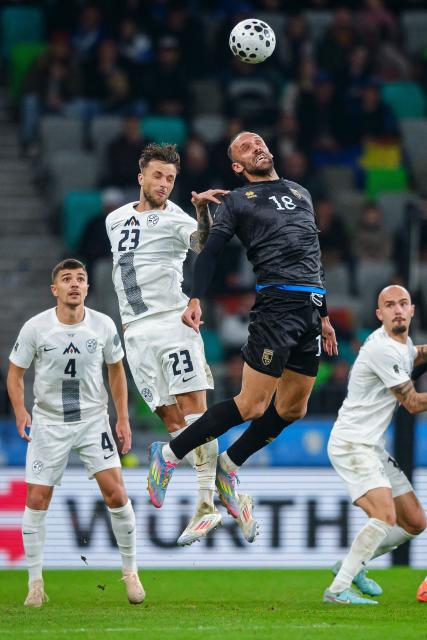 Slovenia's defender #23 David Brekalo (CL) and Kosovo's forward #18 Vedat Muriqi (CR) fight for the ball in the air during the FIFA World Cup 2026 Group B European qualification football match between Slovenia and Kosovo at the Stozice Stadium in Ljubljana, on November 15, 2025. (Photo by Jure Makovec / AFP)