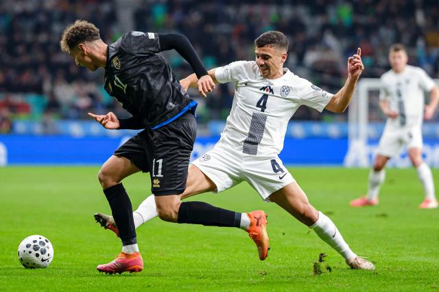 Kosovo's forward #11 Fisnik Asllani (L) and Slovenia's midfielder #04 Dejan Petrovic (R) fight for the ball during the FIFA World Cup 2026 Group B European qualification football match between Slovenia and Kosovo at the Stozice Stadium in Ljubljana, on November 15, 2025. (Photo by Jure Makovec / AFP)