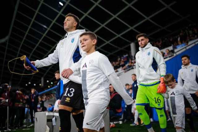 Kosovo's defender #13 Amir Rrahmani (L) and Kosovo's goalkeeper 16 Amir Saipi (R) walk on to the pitch ahead of the FIFA World Cup 2026 Group B European qualification football match between Slovenia and Kosovo at the Stozice Stadium in Ljubljana, on November 15, 2025. (Photo by Jure Makovec / AFP)