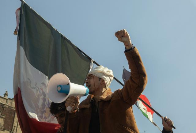 An injured demonstrator shouts slogans during clashes with riot police at a rally against the government of Mexico's President Claudia Sheinbaum at Zocalo Square in Mexico City on November 15, 2025. Thousands of people marched through the streets of Mexico City on Saturday to protest against drug violence and the security policies of President Claudia Sheinbaum's government. (Photo by Eva FONSECA / AFP)