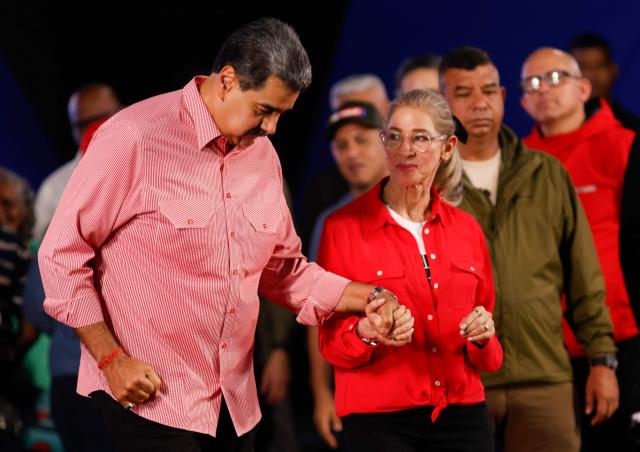 Venezuela's President Nicolas Maduro dances with his wife Cilia Flores during a demonstration for the swearing-in of Bolivarian committees in Caracas on November 15, 2025. (Photo by AFP)