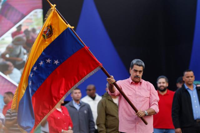 Venezuela's President Nicolas Maduro waves a Venezuelan flag during a demonstration for the swearing-in of Bolivarian committees in Caracas on November 15, 2025. (Photo by AFP)