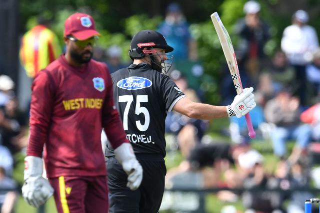 New Zealand's Daryl Mitchell (R) celebrates his half-century during the first one-day international cricket match between New Zealand and West Indies at Hagley Oval in Christchurch on November 16, 2025. (Photo by Sanka Vidanagama / AFP)