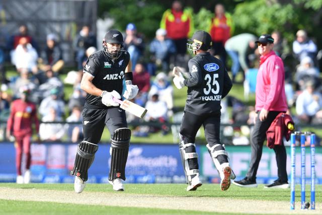 New Zealand's Daryl Mitchell (L) and Zak Foulkes run between the wickets during the first one-day international cricket match between New Zealand and West Indies at Hagley Oval in Christchurch on November 16, 2025. (Photo by Sanka Vidanagama / AFP)