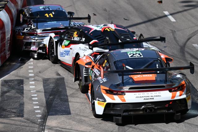Schumacher CLRT Turkish team driver Ayhancan Guven (L) drives his Porsche 911 GT3 R (992) into the barrier as Team Absolute Corsa German driver Luca Engstler (C) and Phantom Global Racing French driver and Dorian Boccolacci (R) crash into him at the start of the FIA GT World Cup race during the 72nd Macau Grand Prix in Macau on November 16, 2025. (Photo by Peter PARKS / AFP)