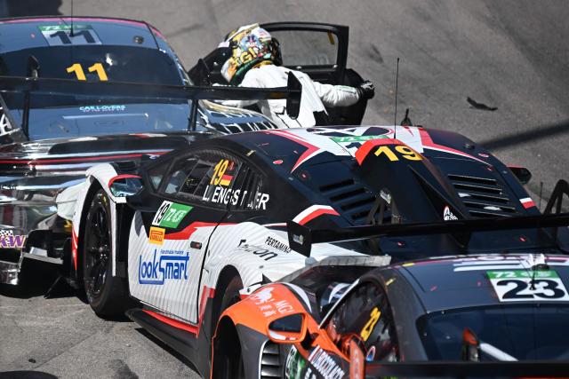 Team Absolute Corsa German driver Luca Engstler (C) checks on Turkish driver Ayhancan Guven after crashing at the start of the FIA GT World Cup race during the 72nd Macau Grand Prix in Macau on November 16, 2025. (Photo by Peter PARKS / AFP)