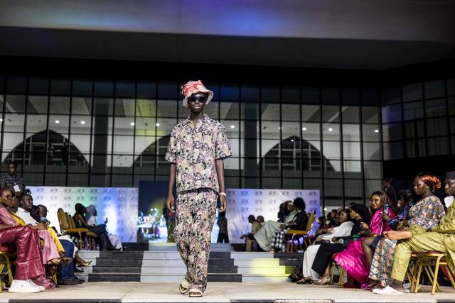 A model walks the catwalk during The Gambia International Fashion Week at Sir Dawda Kairaba Jawara International Conference Centre in Banjul on November 15, 2025. (Photo by Muhamadou BITTAYE / AFP)
