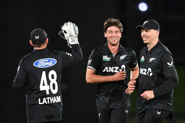 New Zealand's Zak Foulkes (C) celebrates the dismissal West Indies' Shai Hope with his teammates Tom Latham (L) and Michael Bracewell during the first one-day international cricket match between New Zealand and West Indies at Hagley Oval in Christchurch on November 16, 2025. (Photo by Sanka Vidanagama / AFP)