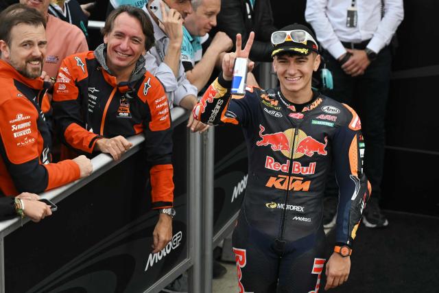 Red Bull KTM Tech3 team's Spanish Moto3 rider Alvaro Carpe (R) celebrates his second place in the Moto3 race of the Valencia Grand Prix at the Ricardo Tormo racetrack in Cheste on November 15, 2025. (Photo by JOSE JORDAN / AFP)