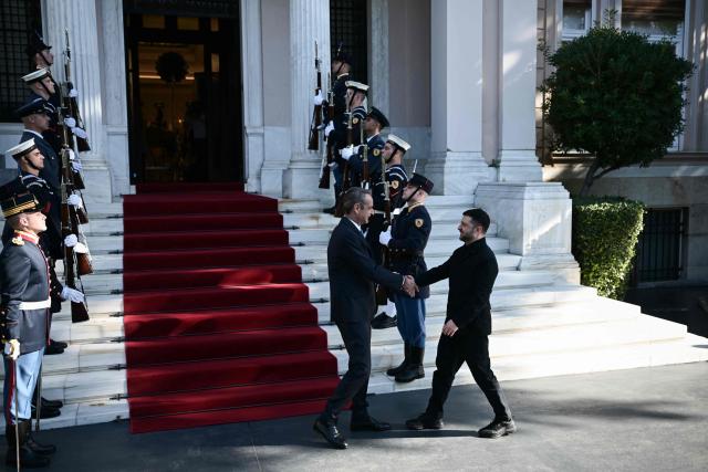Greece's Prime Minister Kyriakos Mitsotakis shakes hands with Ukraine's President Volodymyr Zelensky before their meeting in Athens, on November 16, 2025. (Photo by Angelos Tzortzinis / AFP)