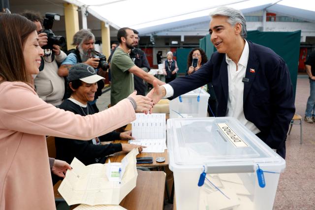 Chile's presidential candidate Marco Enriquez-Ominami, of the Progressive Party, greets polling station officials upon arrival to vote during the general election in Santiago on November 16, 2025. Chileans are voting in a presidential election shaped by rising concerns over violent crime, with candidates pledging tougher measures against transnational gangs and the far-right promising to carry out mass migrant deportations. (Photo by Raul BRAVO / AFP)