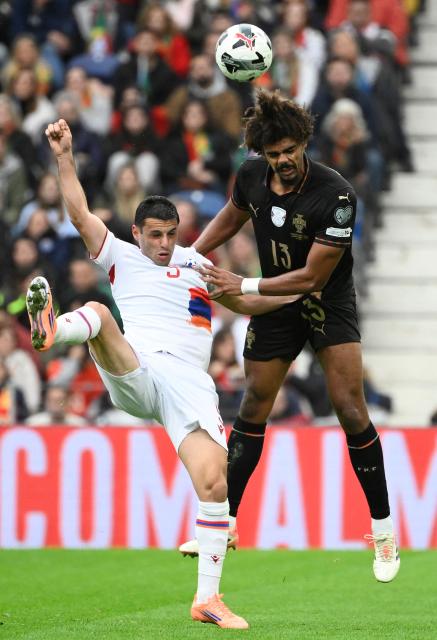 Armenia's forward #09 Artur Serobyan and Portugal's defender #13 Renato Veiga vie for a header during the 2026 World Cup qualifiers Europe zone group F football match between Portugal and Armenia, at Dragao stadium in Porto on November 16, 2025. (Photo by Miguel RIOPA / AFP)