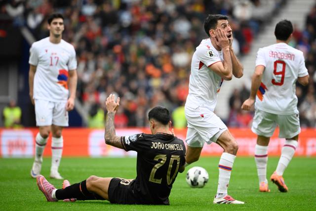 Armenia's midfielder #20 Karen Muradyan (2R) reacts next to Portugal's forward #20 Joao Cancelo during the 2026 World Cup qualifiers Europe zone group F football match between Portugal and Armenia, at Dragao stadium in Porto on November 16, 2025. (Photo by Miguel RIOPA / AFP)