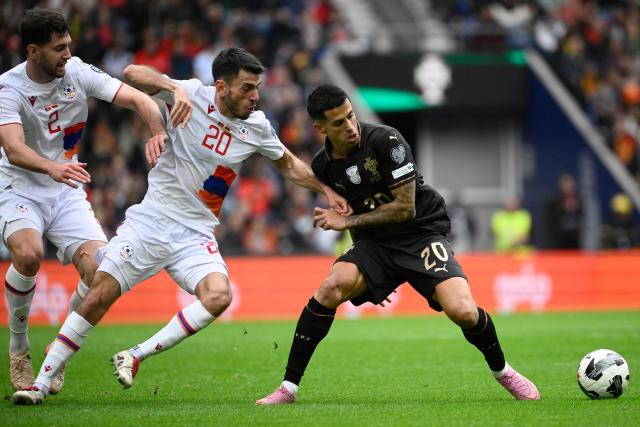 Armenia's midfielder #20 Karen Muradyan and Portugal's forward #20 Joao Cancelo fight for the ball during the 2026 World Cup qualifiers Europe zone group F football match between Portugal and Armenia, at Dragao stadium in Porto on November 16, 2025. (Photo by Miguel RIOPA / AFP)