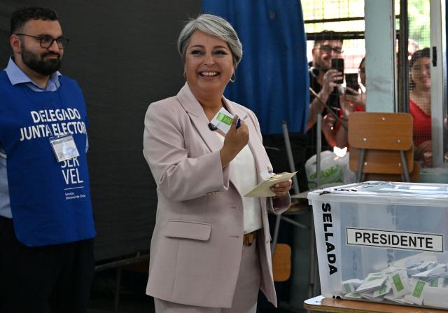 Chile's presidential candidate Jeannette Jara, of the Unidad por Chile coalition, shows her ballot before casting her vote during the general election in Santiago on November 16, 2025. Chileans are voting in a presidential election shaped by rising concerns over violent crime, with candidates pledging tougher measures against transnational gangs and the far-right promising to carry out mass migrant deportations. (Photo by RODRIGO ARANGUA / AFP)