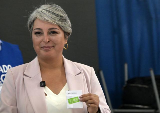 Chile's presidential candidate Jeannette Jara, of the Unidad por Chile coalition, shows her ballot before casting her vote during the general election in Santiago on November 16, 2025. Chileans are voting in a presidential election shaped by rising concerns over violent crime, with candidates pledging tougher measures against transnational gangs and the far-right promising to carry out mass migrant deportations. (Photo by Rodrigo ARANGUA / AFP)