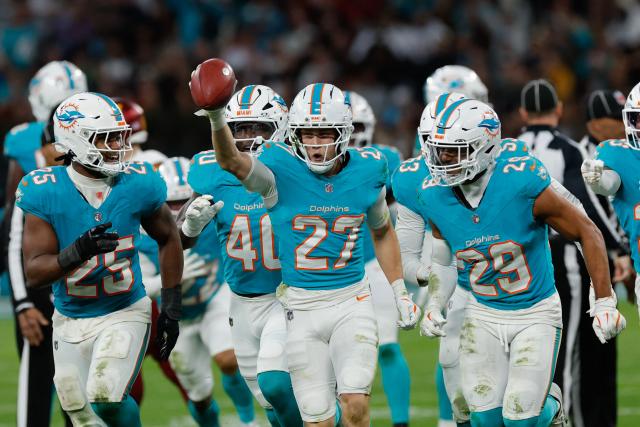 Miami Dolphins' cornerback #27 Ethan Bonner (C) and teammates celebrate recovering possession after a kickoff during the fourth quarter of their NFL match between Miami Dolphins and Washington Commanders at Santiago Bernabeu Stadium in Madrid on November 16, 2025. (Photo by Oscar DEL POZO / AFP)