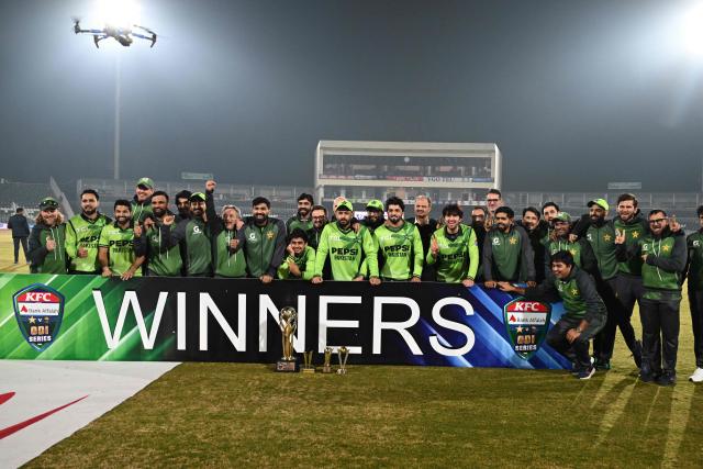 Pakistan's players and team officials pose with trophy at the end of the third one-day international (ODI) cricket match between Pakistan and Sri Lanka at the Rawalpindi Cricket Stadium, in Rawalpindi, on November 16, 2025. (Photo by Aamir QURESHI / AFP)