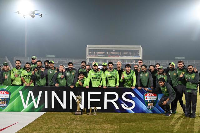Pakistan's players and team officials pose with trophy at the end of the third one-day international (ODI) cricket match between Pakistan and Sri Lanka at the Rawalpindi Cricket Stadium, in Rawalpindi, on November 16, 2025. (Photo by Aamir QURESHI / AFP)
