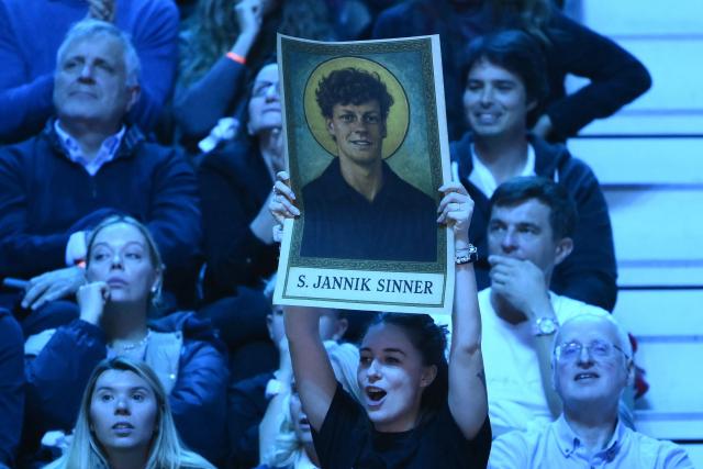 A spectator holds a banner during the men's single final match between Italy's Jannik Sinner and Spain's Carlos Alcaraz at the ATP Finals tennis tournament, in Turin, on November 16, 2025. (Photo by Marco BERTORELLO / AFP)