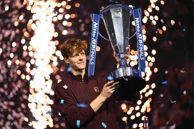 Italy's Jannik Sinner lifts the trophy after winning over Spain's Carlos Alcaraz at the end of the men's single final match at the ATP Finals tennis tournament, in Turin, on November 16, 2025. (Photo by Marco BERTORELLO / AFP)