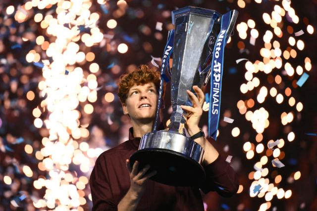 TOPSHOT - Italy's Jannik Sinner lifts the trophy after winning over Spain's Carlos Alcaraz at the end of the men's single final match at the ATP Finals tennis tournament, in Turin, on November 16, 2025. (Photo by Marco BERTORELLO / AFP)