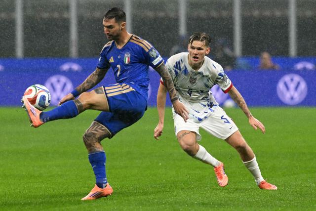 Italy's forward #07 Matteo Politano fights for the ball with Norway's  forward #05 David Moller Wolfe during the FIFA World Cup 2026 European qualification football match between Italy and Norway, at the San Siro Stadium, in Milan, on November 16, 2025. (Photo by Stefano RELLANDINI / AFP)