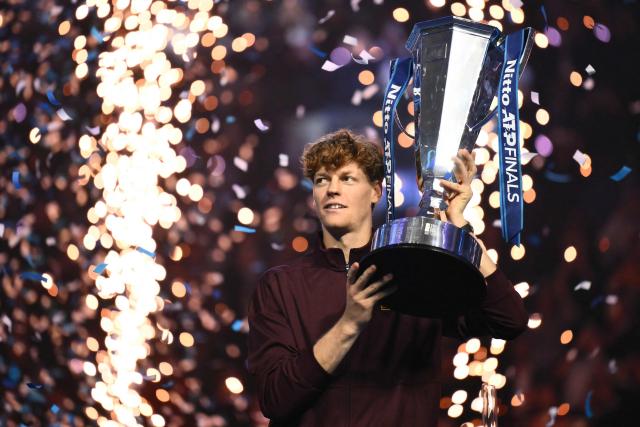 Italy's Jannik Sinner lifts the trophy after winning over Spain's Carlos Alcaraz at the end of the men's single final match at the ATP Finals tennis tournament, in Turin, on November 16, 2025. (Photo by Marco BERTORELLO / AFP)