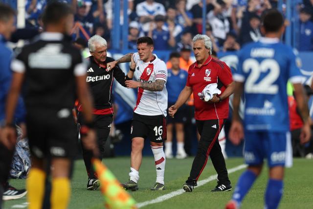 River Plate's defender #16 Fabricio Bustos leaves the pitch after being injured during the Argentine Professional Football League 2025 Clausura Tournament match between Velez Sarsfield and River Plate at the Jose Amalfitani Stadium in Buenos Aires on November 16, 2025. (Photo by Alejandro PAGNI / AFP)