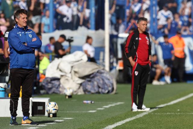 Velez Sarsfield's head coach Guillermo Barros Schelotto (L) watches the game next to River Plate's head coach Marcelo Gallardo (R) during the Argentine Professional Football League 2025 Clausura Tournament match between Velez Sarsfield and River Plate at the Jose Amalfitani Stadium in Buenos Aires on November 16, 2025. (Photo by Alejandro PAGNI / AFP)