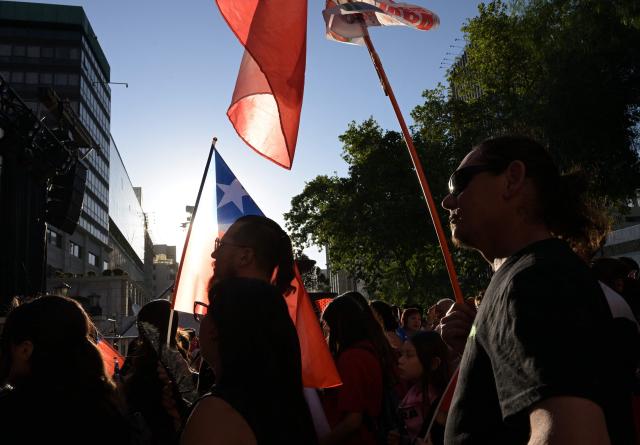 Supporters of Chile's presidential candidate Jeannette Jara, of the Unidad por Chile coalition, wait for the first results during the general election, in Santiago on November 16, 2025. Chileans stood in long lines on Sunday to vote in general elections dominated by far-right calls for an iron fist on crime and mass migrant deportations. (Photo by Rodrigo ARANGUA / AFP)