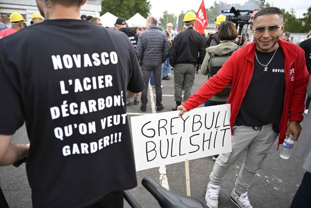 (FILES) A protester wears a shirt reading "NovAsco, the decarbonised steel we want to keep" flanked by another with a placard as employees of steel manufacturer NovAsco Hagondange and elected representatives of Moselle demonstrate during a citizen's march in support of the factory's employees, in Hagondange, northeastern France, on September 4, 2025. France's ministry of Industry announced to AFP on November 17 that the government will seek legal action against Greybull, the investment fund that took over Ascometal in 2024.
A decision by the commercial division of the Strasbourg court will be presented on November 17, after the takeover bids were presented on November 12. Ascometal was taken over on July 20, 2024 by Greybull investment fund under the name NovAsco. (Photo by Jean-Christophe VERHAEGEN / AFP)